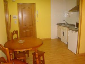 cocina con mesa de madera y cocina con fregadero en Apartamentos Peña Mar en Castropol