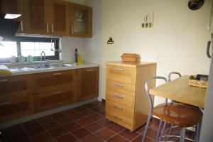 a kitchen with wooden cabinets and a table and a sink at La casa di Clelia in Cercola +11 photos