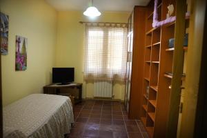 a bedroom with a bed and a television and a window at La casa di Clelia in Cercola