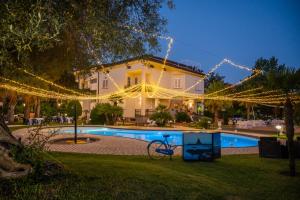 a house with a swimming pool and christmas lights at B&B Blanc Maison Etna Relais & Charme in Nicolosi