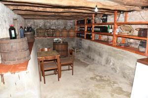 Seosko domacinstvo Imanje Medojevic في مويكوفاتش: غرفة مع طاولة وكراسي وزجاجات النبيذ