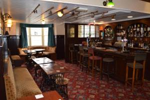 a bar in a restaurant with tables and chairs at The Masons Arms in Norham