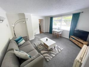a living room with a couch and a table at 2 Chatsworth Riverscape Apartments - Peaceful apartment in great location with free parking overlooking the Gannel just a short walk from Newquays incredible beaches and local amenities in Newquay