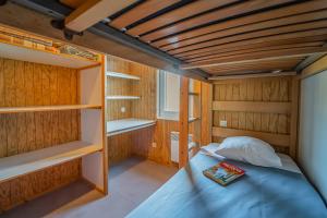 a bedroom with bunk beds and a book on the bed at Les Chalets de la Truyère in Le Malzieu-Ville +9 photos