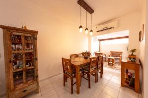 Un comedor con mesa y sillas de madera. en Casa Guarujá - Condomínio, en Guarujá