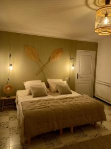 ein Schlafzimmer mit einem großen Bett mit Blättern an der Wand in der Unterkunft LES VIGNES in Mormoiron