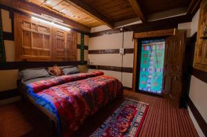 a bedroom with a bed and a window and a rug at Folktales Residency in Saturang