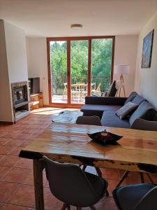 een woonkamer met een bank en een houten tafel bij Alojamiento Rural Los Gancheros in Tragacete