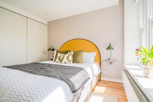 a bedroom with a large bed with a large orange headboard at Be London - The Covent Garden Residences in London