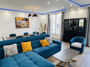 - un salon avec un canapé bleu et des chaises dans l'établissement Le jardin d'Eden, à Reims