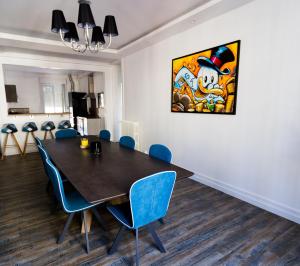 une salle à manger avec une table et des chaises bleues dans l'établissement Le jardin d'Eden, à Reims