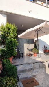 a patio with an umbrella and some plants at Villa Sogno in Castel Fusano