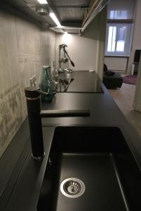 Apartment 43 في بودابست: أعلى منضدة سوداء مع حوض في مطبخ