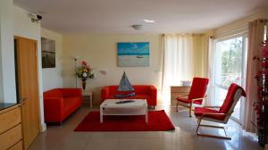 a living room with two red chairs and a table at Вила Сънрайз - Villa Sunrise in Varna City