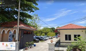 a building with a car parked in a parking lot at Kamar Musafir MMS in Ipoh