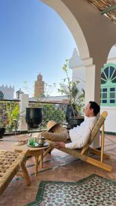 een man op een stoel op een patio bij Riad Catalina in Marrakesh