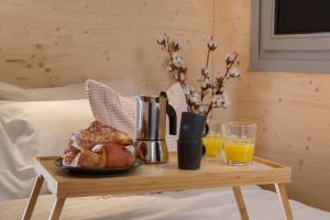 a table with a plate of bread and two glasses of orange juice at HelloChalet - Chalet Northern Lights - Family Ski Chalet with garden walking distance lift in Valtournenche