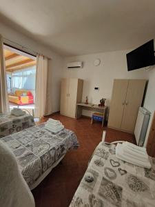 Habitación con 2 camas y TV. en Casa Mendez, en Buseto Palizzolo