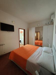 1 dormitorio con 1 cama grande con manta naranja en Casa Mendez, en Buseto Palizzolo