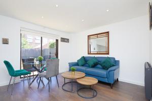 a living room with a blue couch and a table at Modern 2 Bed House by City Centre in Nottingham