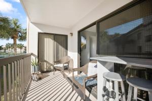 a balcony with chairs and a table on a balcony at Ocean Village Club J24 in Saint Augustine