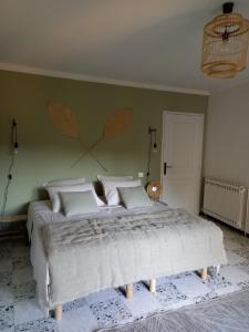 ein Schlafzimmer mit einem großen Bett und einer grünen Wand in der Unterkunft LES VIGNES in Mormoiron