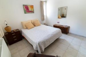 1 dormitorio con cama, tocador y espejo en Casa d'Arte, en Vrachati