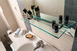 baño con lavabo y estante de cristal sobre un fregadero en Casa d'Arte, en Vrachati