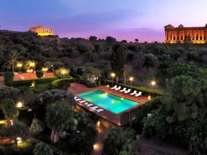 una vista aerea di una piscina di notte con un edificio di Villa Athena Resort a Agrigento