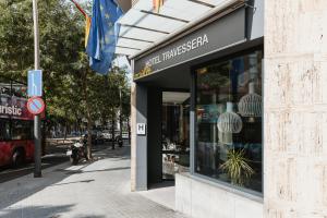 una tienda frente a un edificio en una calle de la ciudad en Hotel Travessera, en Barcelona