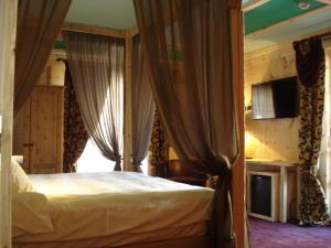 a bedroom with a bed and a window with curtains at Relais du Chateau Blanc in La Thuile