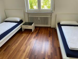 Habitación con 2 camas y suelo de madera. en Skyblue, en Friedrichshafen