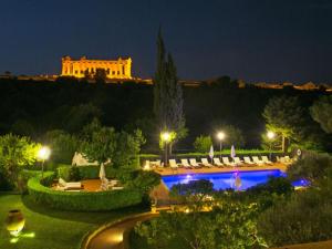 un resort con piscina e un edificio di notte di Villa Athena Resort a Agrigento