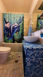 a bathroom with a sink and a dolphin shower curtain at IOANNIS - Room with balcony near Limnopula in Gavrolímni