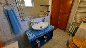 La salle de bains est pourvue d'un lavabo blanc et d'une douche. dans l'établissement IOANNIS - Room with balcony near Limnopula, à Gavrolímni
