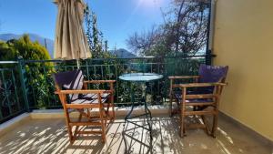 d'une terrasse avec 2 chaises et une table sur un balcon. dans l'établissement IOANNIS - Room with balcony near Limnopula, à Gavrolímni