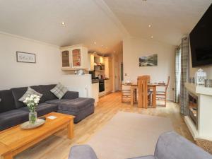 a living room with a couch and a table at Tiggywinkle Beck Lodge in Windermere