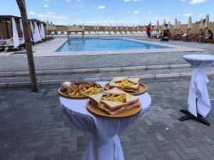 een bord eten op een tafel naast een zwembad bij Sunset vila sa bazenom in Lebane