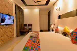 a hotel room with a bed and a tv on the wall at Hotel The Yellow in Chandīgarh