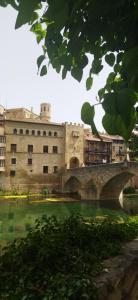 巴爾德羅夫雷斯的住宿－LAMAR Valderrobres，一座古老的石头建筑,有一座河上的桥梁