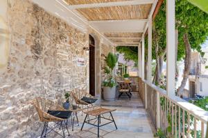 eine Terrasse mit Stühlen und Tischen an einer Steinmauer in der Unterkunft Castelvecchio Suites in Rethymno