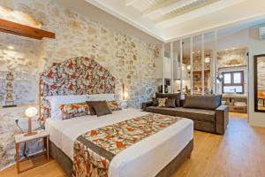 ein Schlafzimmer mit einem großen Bett und einem Sofa in der Unterkunft Castelvecchio Suites in Rethymno