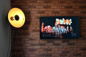 un mur avec une télévision et une lampe à côté d'un mur de briques dans l'établissement Appartement cosy & moderne à 180m de la plage, à Sanary-sur-Mer