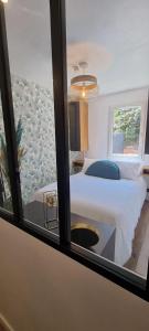 - une chambre avec un grand lit blanc et une fenêtre dans l'établissement Appartement cosy & moderne à 180m de la plage, à Sanary-sur-Mer