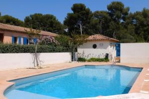 une piscine en face d'une maison avec une clôture blanche dans l'établissement Appartement cosy & moderne à 180m de la plage, à Sanary-sur-Mer