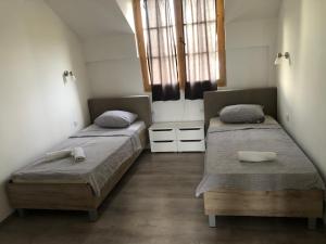 two twin beds in a room with two windows at STD JOVIC sa bazenom in Lebane