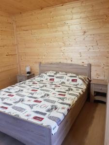 Cama en habitación con pared de madera en Бунгало парк Summer Life en Tyulenovo