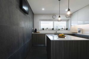 a kitchen with a bowl of fruit on a counter at Sesimbra Stylish Villa by Homing in Sesimbra
