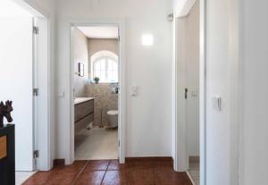 a white bathroom with a toilet and a sink at Sesimbra Stylish Villa by Homing in Sesimbra