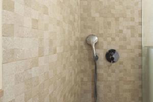 セジンブラにあるSesimbra Stylish Villa by Homingのレンガの壁にシャワーヘッド付きのシャワーが備わります。